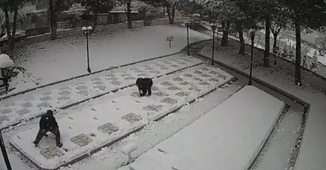 Çanakkale’de 2 çocuk karla kaplanan şehitlikteki mezar taşlarını temizledi